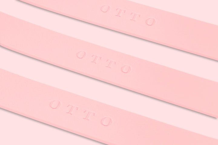 Close-up of pink waterproof collars. The collars have the names embossed on them.