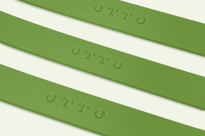 Close-up of three olive green waterproof collars. The collars have the names embossed on them.