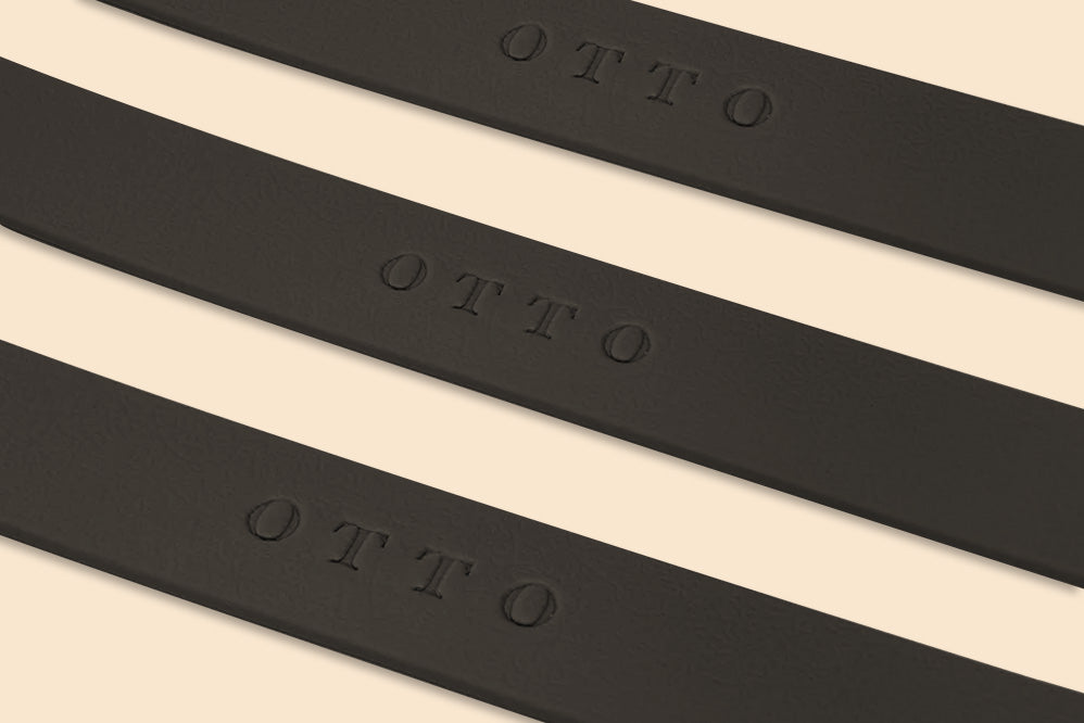 Close-up of three black waterproof collars. The collars have the names embossed on them.